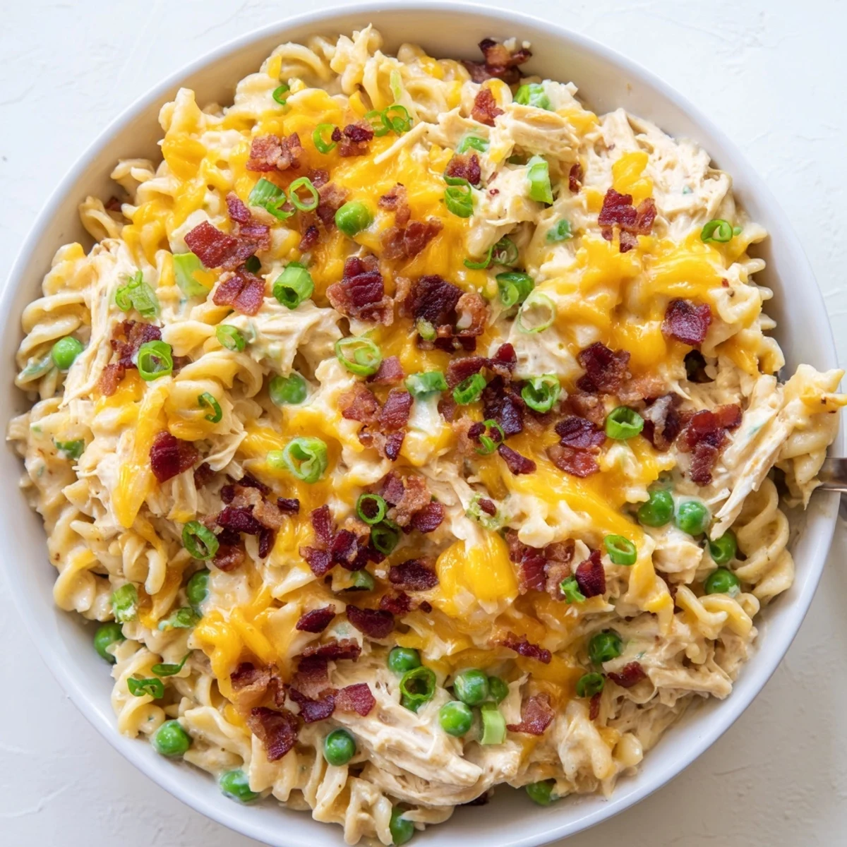 Hearty crack chicken casserole featuring shredded chicken breast, rotini pasta and bacon pieces in a rich cheese sauce