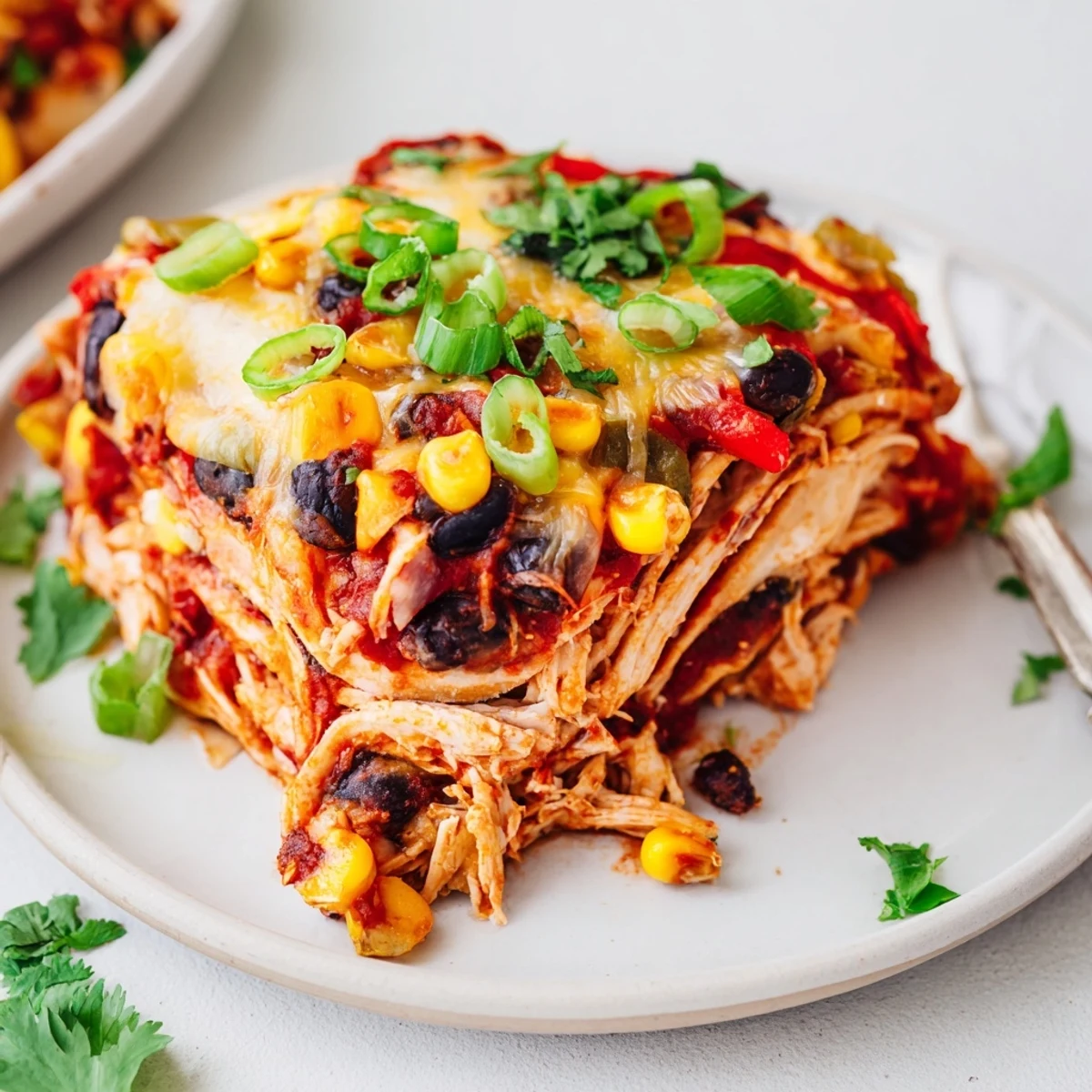 Layered Crockpot Chicken Enchilada Casserole bubbling with melted cheese and colorful vegetables