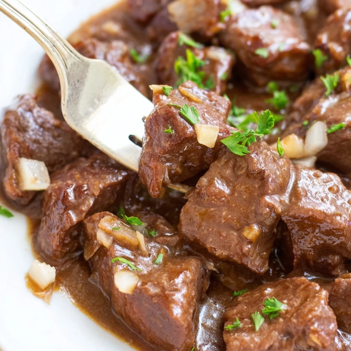 Slow cooker beef tips and gravy smothered in rich brown sauce over creamy mashed potatoes