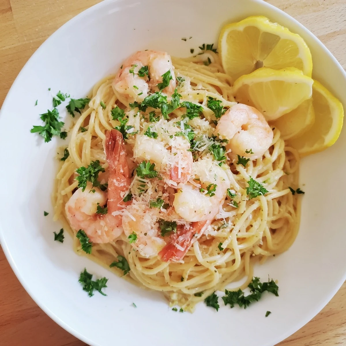 Creamy shrimp scampi pasta drizzled with white wine lemon sauce and sprinkled with Parmesan cheese
