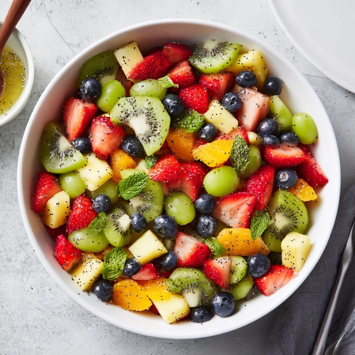 Colorful Easter fruit salad bowl overflowing with fresh strawberries, pineapple, kiwi, and blueberries garnished with mint