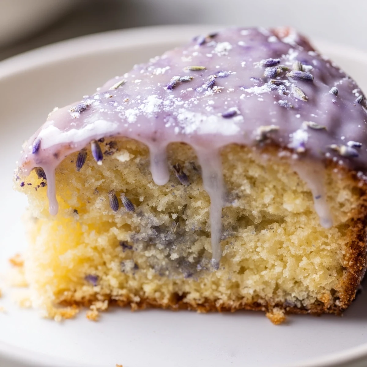 Soft lavender cake topped with zesty lemon icing and scattered purple buds