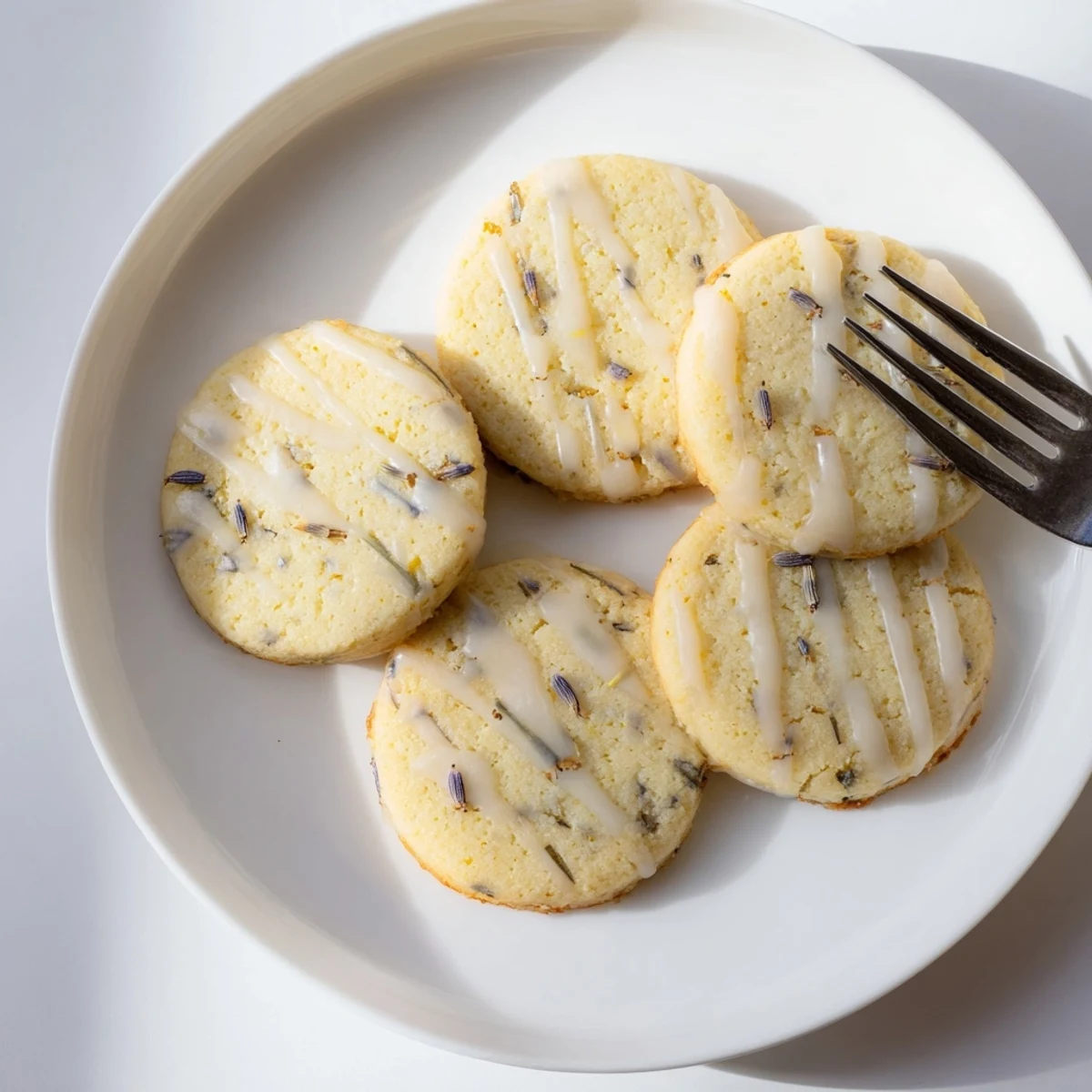 Soft lemon lavender cookies arranged on parchment with visible citrus zest throughout