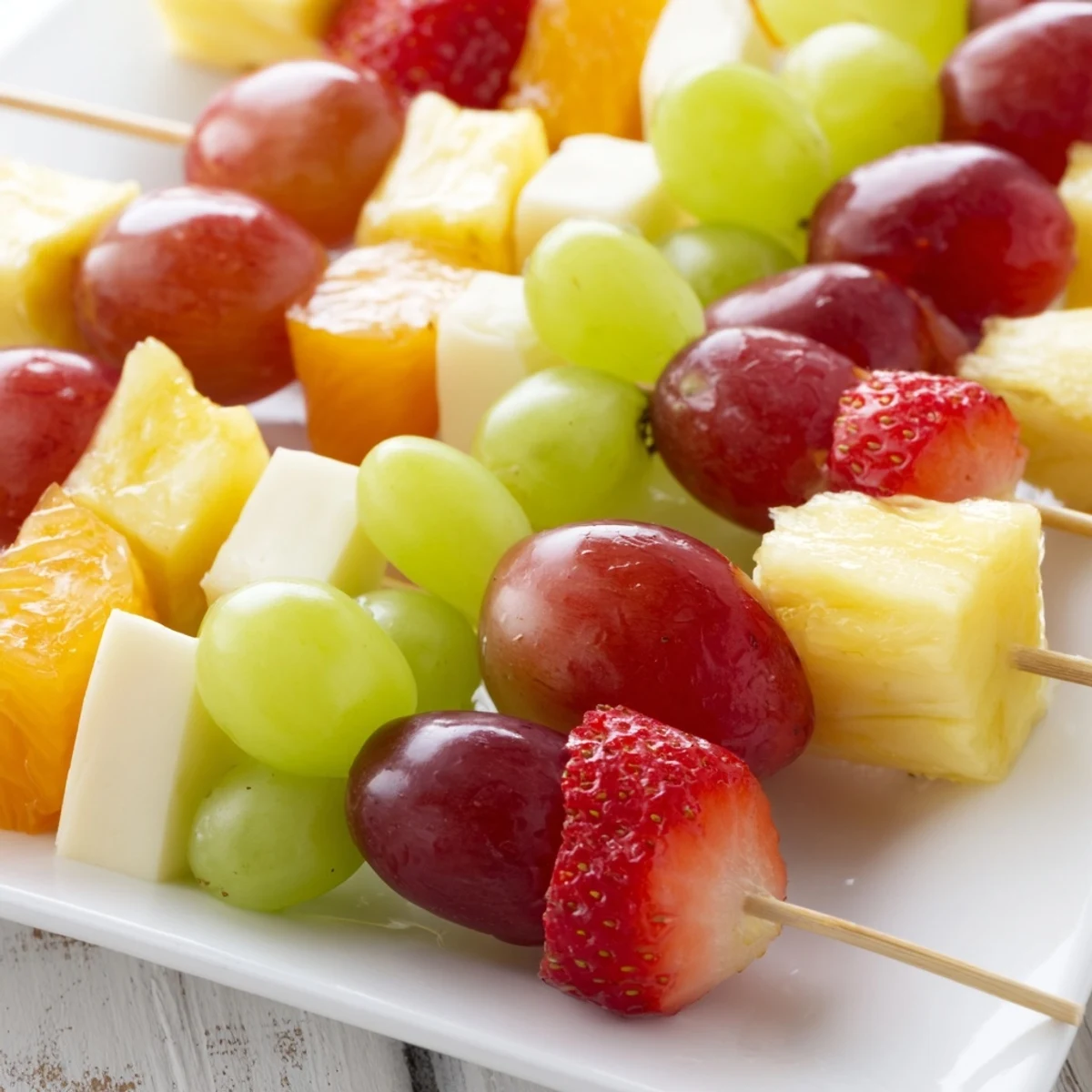 Juicy pineapple and creamy Monterey Jack skewers garnished with bright green mint leaves