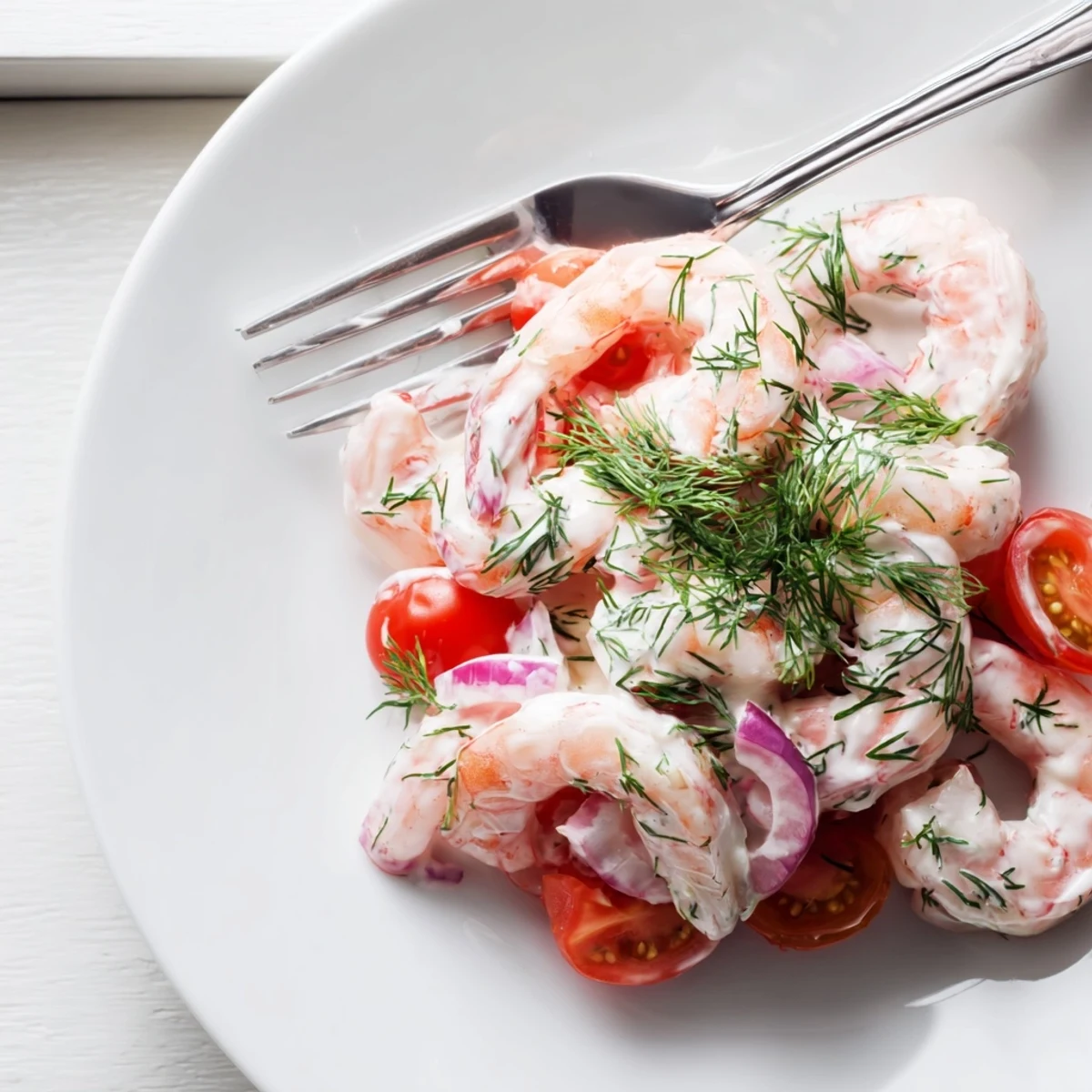 Creamy shrimp salad recipe served in a bowl with diced cucumber and celery.
