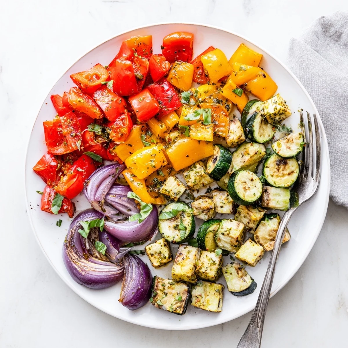 Golden tender zucchini and cherry tomatoes in classic Mediterranean roasted vegetables drizzled with olive oil.