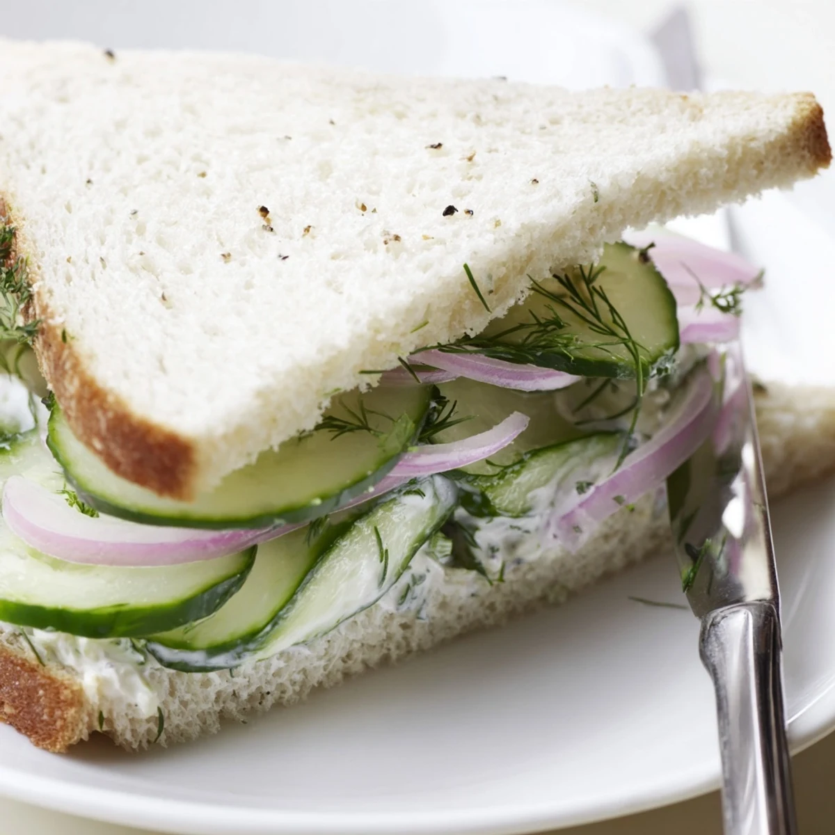 Sunlit picnic scene with Quick Cucumber Salad Sandwiches stacked on plate