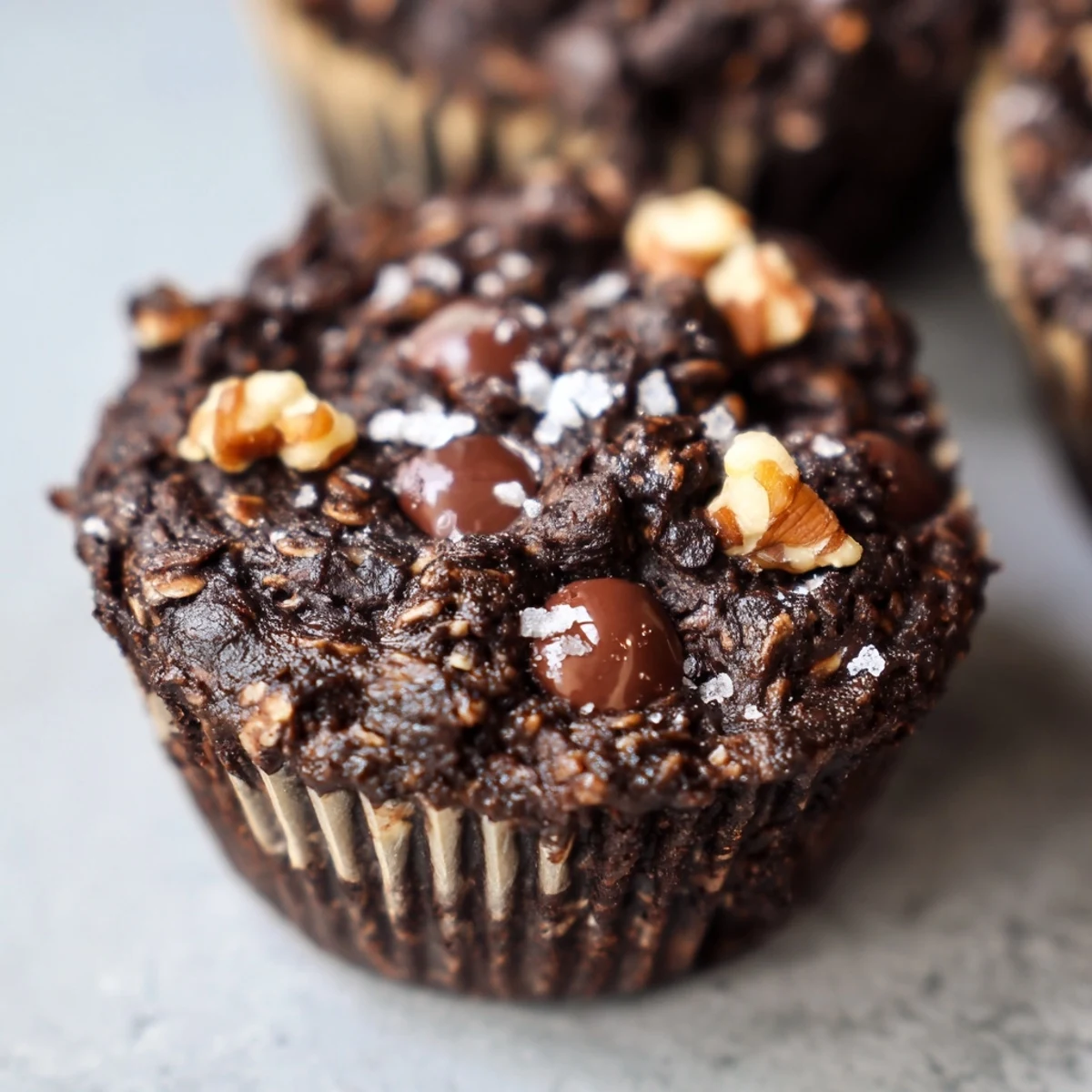 Fudgy dark chocolate oatmeal cups topped with flaky sea salt on a wire rack