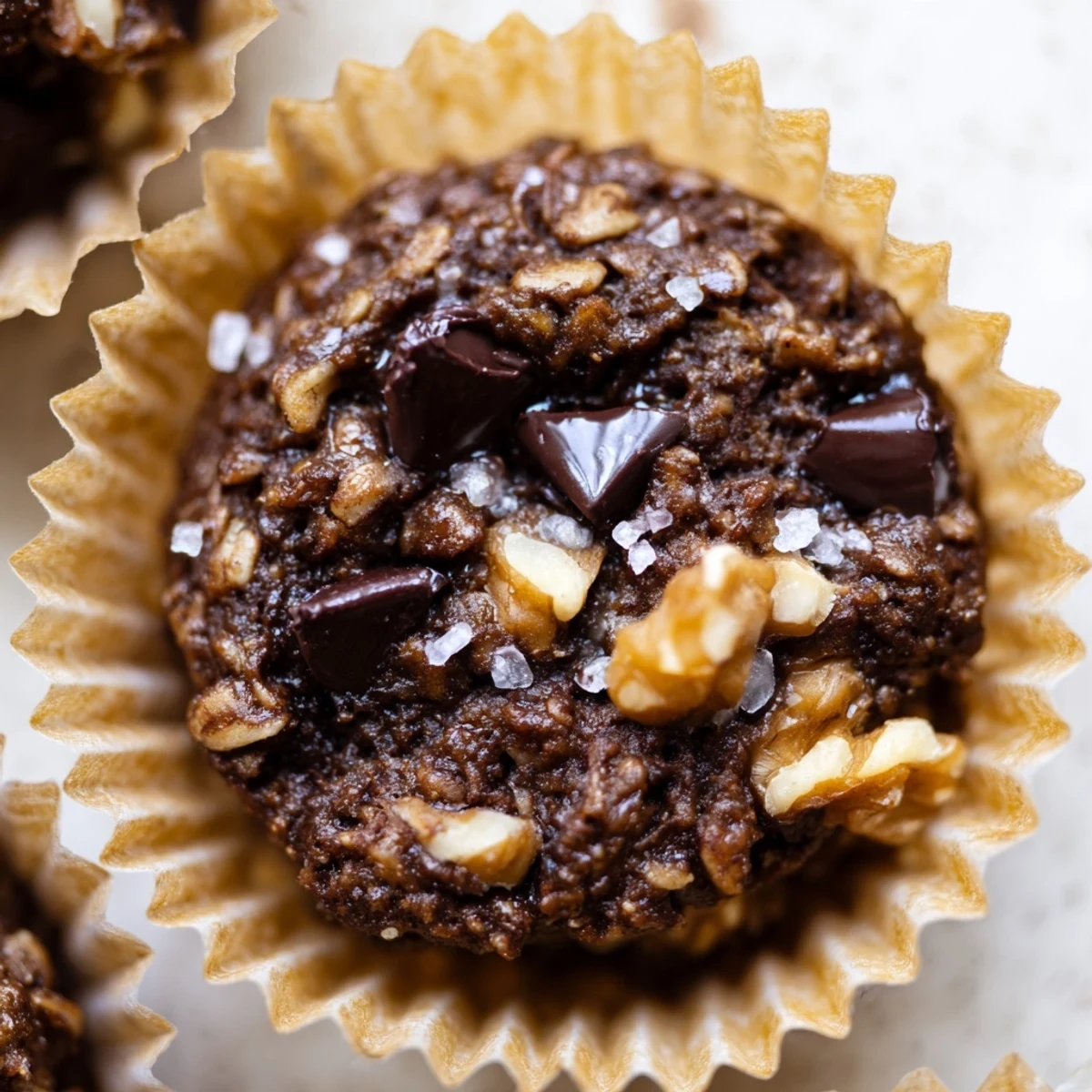 Dark chocolate oatmeal cups with melty chips and nuts in a muffin tin