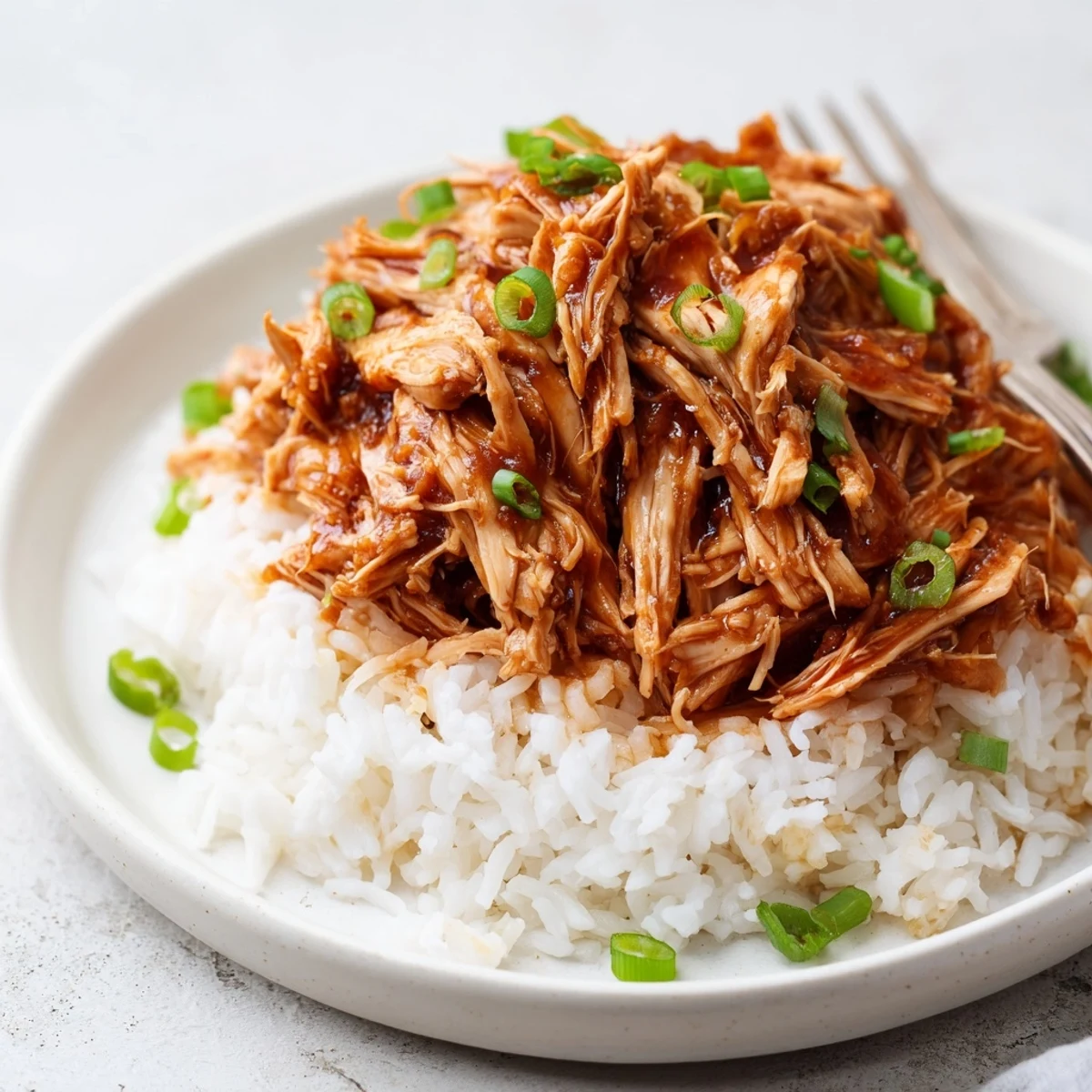 Crockpot Honey Garlic Chicken simmering in glossy sauce over steamed white rice