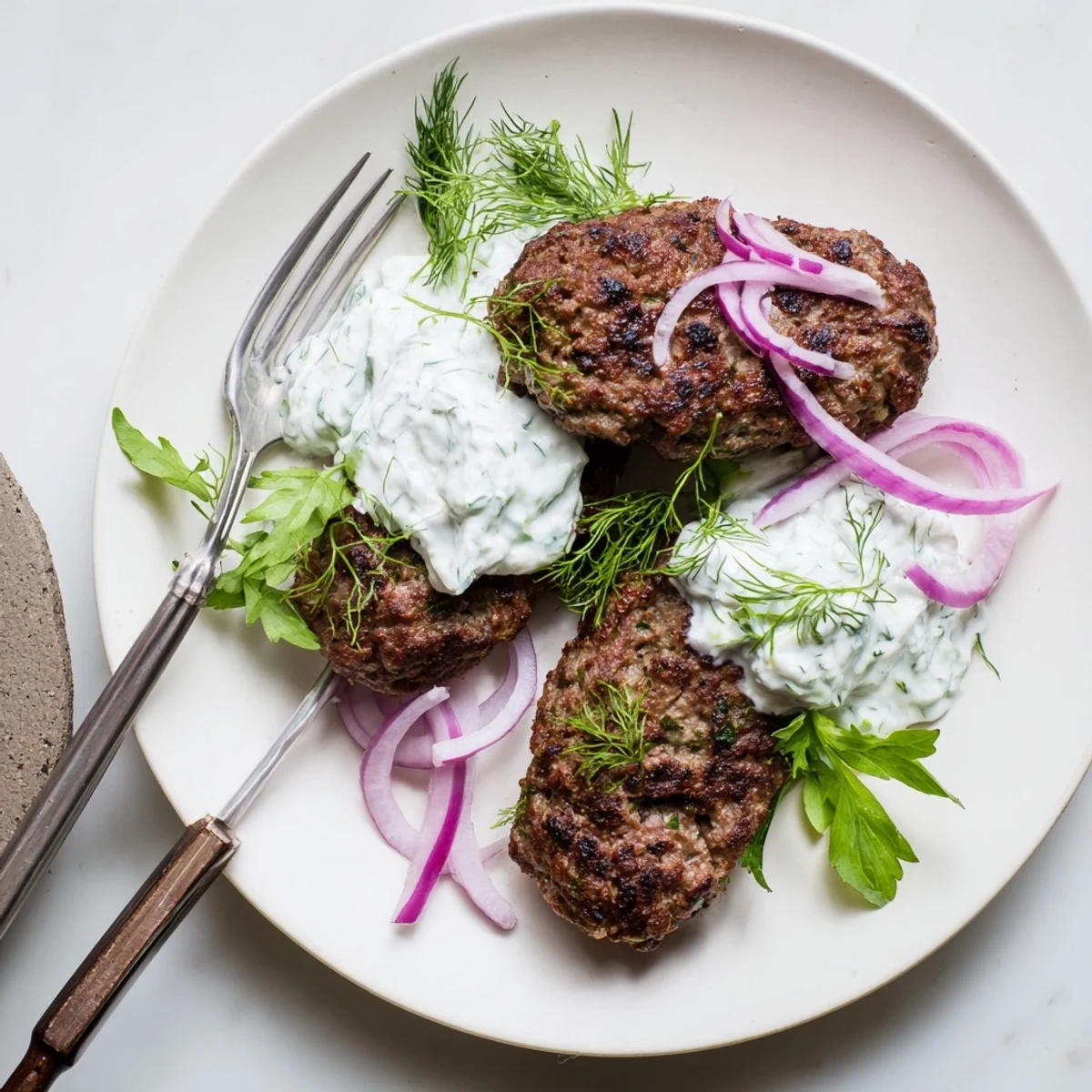 Hand-shaped ground beef patties seared to perfection with cool cucumber yogurt dipping sauce