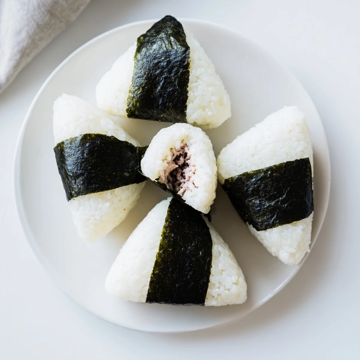 Handheld tuna mayo onigiri rice ball wrapped with crispy nori seaweed strip