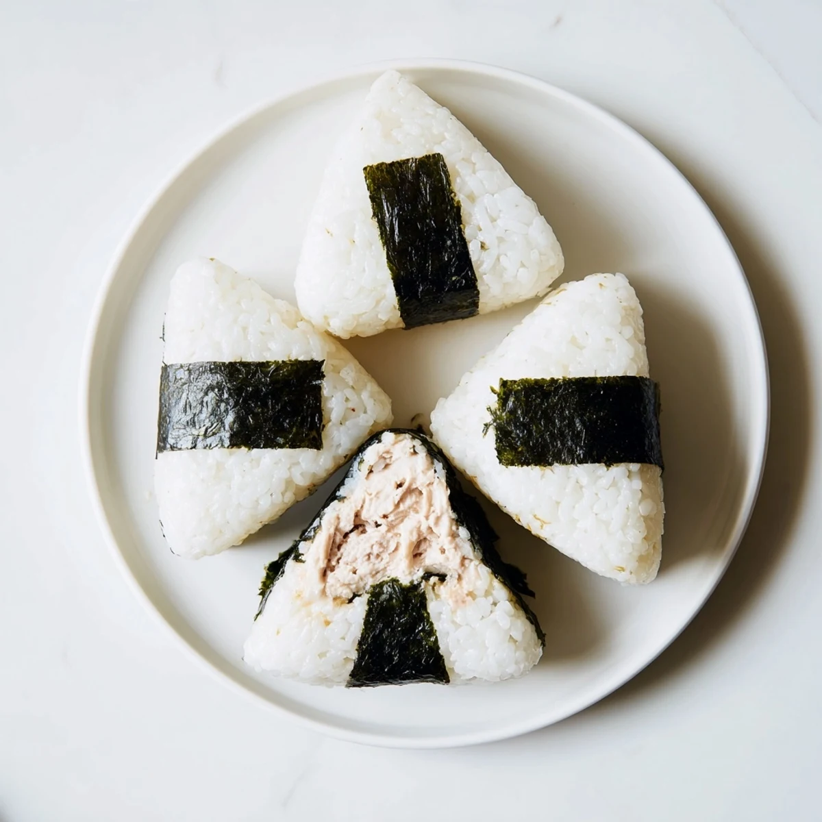 Triangle shaped Japanese tuna mayonnaise onigiri held in hand for lunchbox