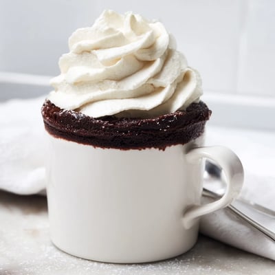 Rich gluten free chocolate mug cake in a white mug, ready to serve in minutes.